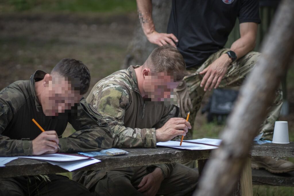 Kandydaci OSŻW Warszawa wypełniają psychotesty przy stole podczas Hell Week