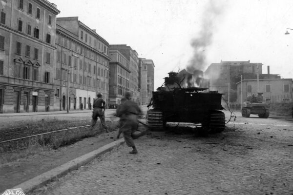 Żołnierze 1st Special Service Force wychodzą zza płonącego czołgu na ulicy Rzymu, czerwiec 1944