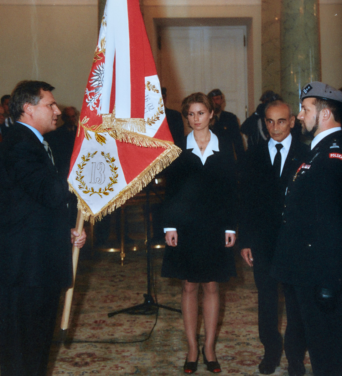 Prezydent Aleksander Kwaśniewski wręcza sztandar JW GROM; obok matka chrzestna Agnieszka Petelicka, na płacie widoczny numer 13