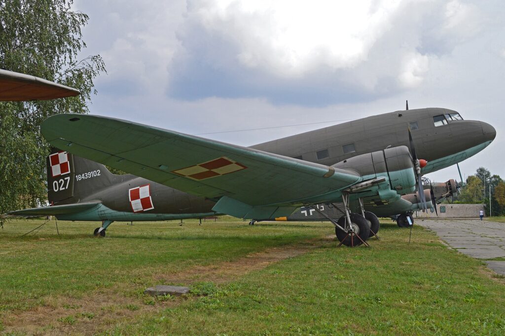 Samolot transportowy Li-2T w polskich barwach wojskowych, z szachownicami i numerem 027, na ekspozycji muzealnej