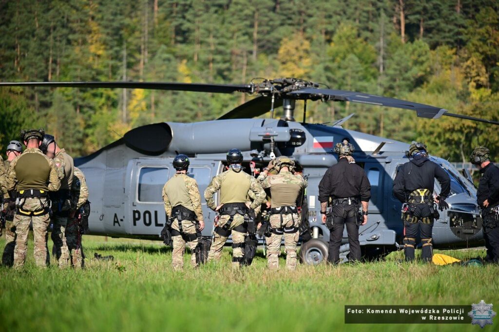 Policyjny śmigłowiec S-70i Black Hawk na polanie w Bieszczadach, wokół funkcjonariusze w wyposażeniu taktycznym