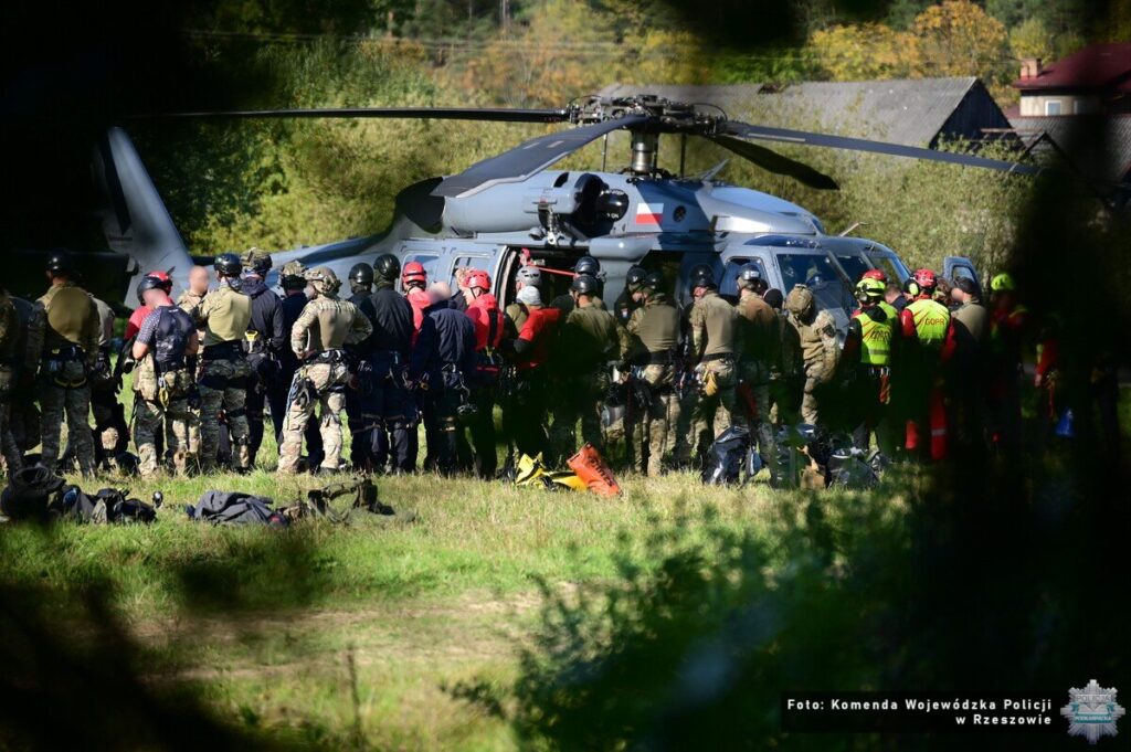 Uczestnicy ćwiczeń zgromadzeni przy policyjnym śmigłowcu Black Hawk