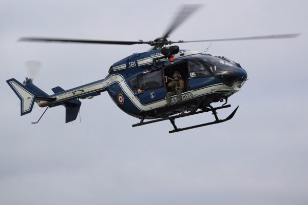 Snajper francuskiej jednostki GIGN w otwartych drzwiach śmigłowca EC145 żandarmerii
