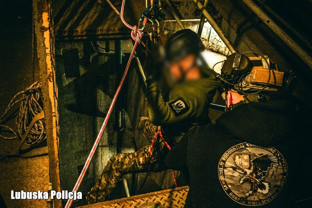 Operator porusza się na linie wewnątrz hali przemysłowej